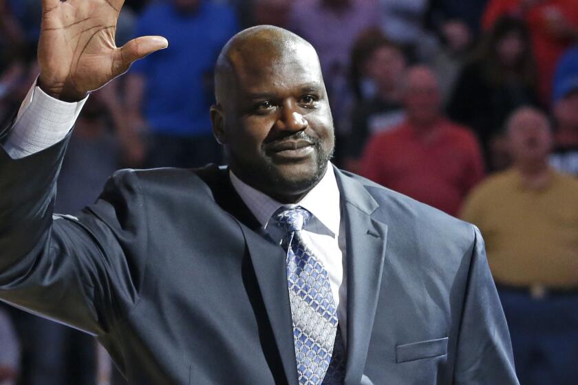 Shaquille O'Neal waves to fans while being honored during a game between the Orlando Magic and Detroit Pistons on March 27, 2015.