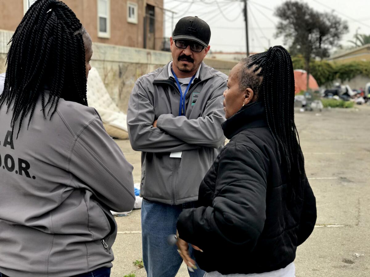 LA DOOR field team supervisor Jose Rodriguez confers with two of his outreach workers