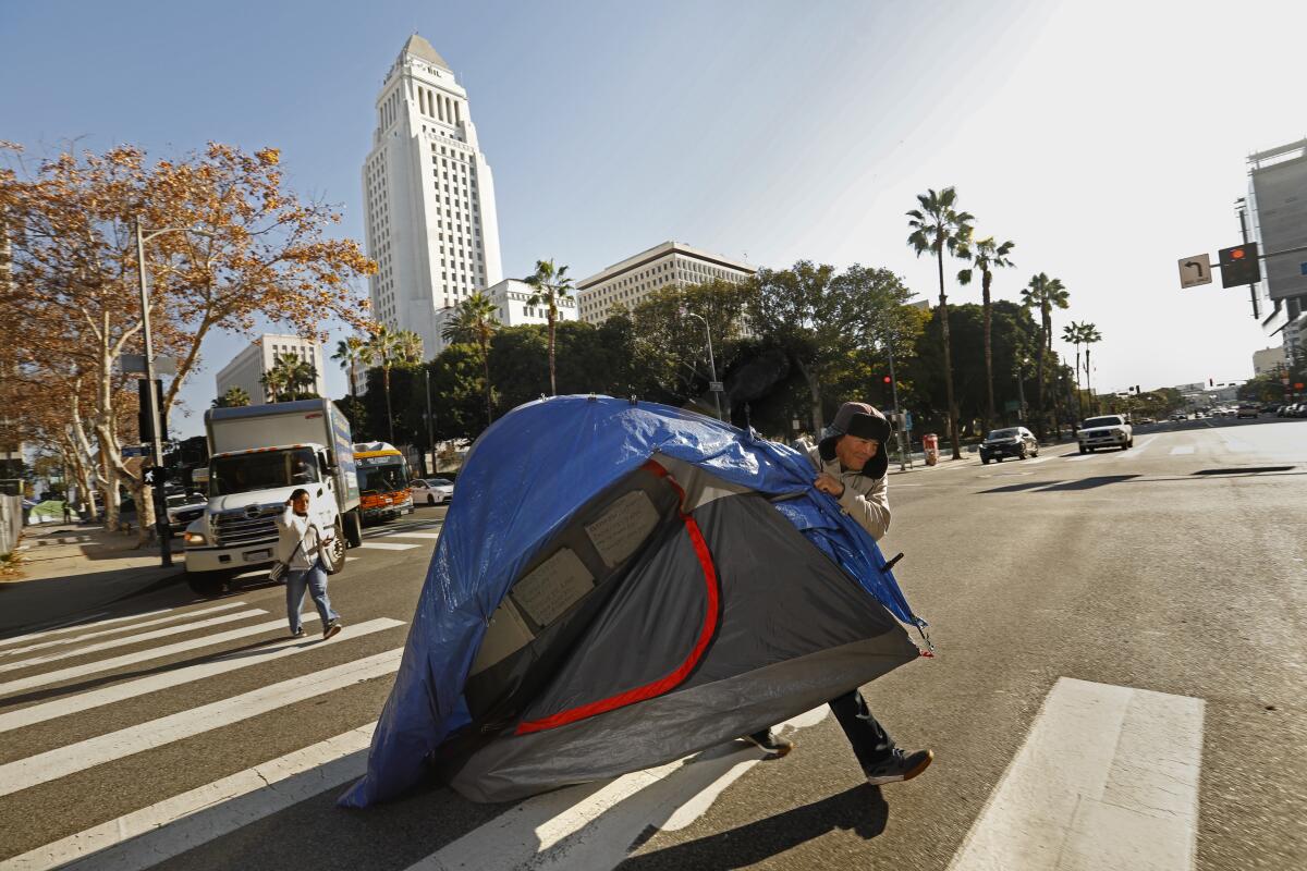 Eduardo Carmona, 50, moves his tent across 1st Street in downtown Los Angeles.