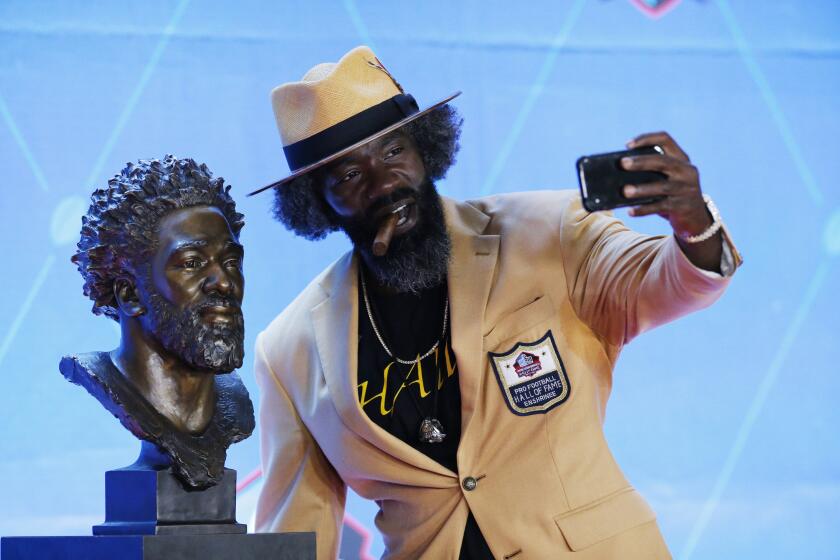 Former NFL player Ed Reed takes a selfie with his Pro Football Hall of Fame bust during inductions at the hall Saturday, Aug. 3, 2019, in Canton, Ohio. (AP Photo/Ron Schwane)