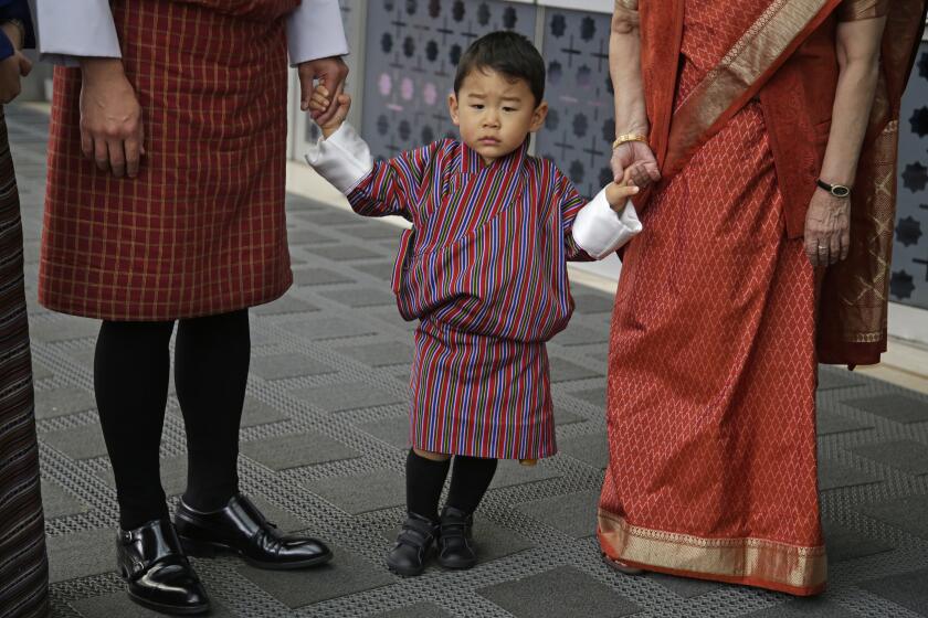 Indian External Affairs Minister Sushma Swaraj, partially seen right, poses with Bhutan’s King Jigme Khesar Namgyal Wangchuck, partially seen second left, Queen Jetsun Pema, partially seen, left and their son prince Jigme Namgyel Wangchuck, second right after receiving them at the airport in New Delhi, India, Tuesday, Oct. 31, 2017. The Bhutan royals arrived Tuesday on a four-days visit to India. (AP Photo/Altaf Qadri)