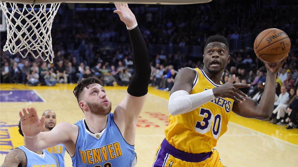 Lakers forward Julius Randle, right, shoots as Denver Nuggets center Jusuf Nurkic defends during the first half Tuesday.