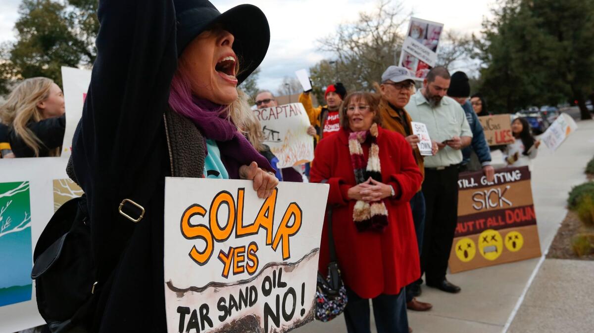 Edie Pistolesi, left, protests with other supporters and Porter Ranch residents outside SoCal Gas in Chatsworth to oppose the construction of new gas turbines at the Aliso Canyon gas storage facility, the site of a gas leak last year that displaced thousand of residents.
