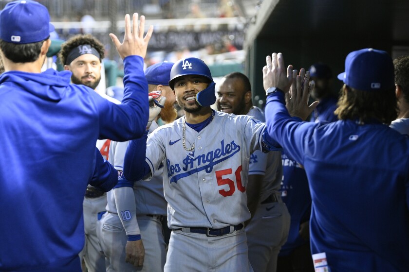 Dodgers' Mookie Betts celebrates his home run in the dugout with his teammates.