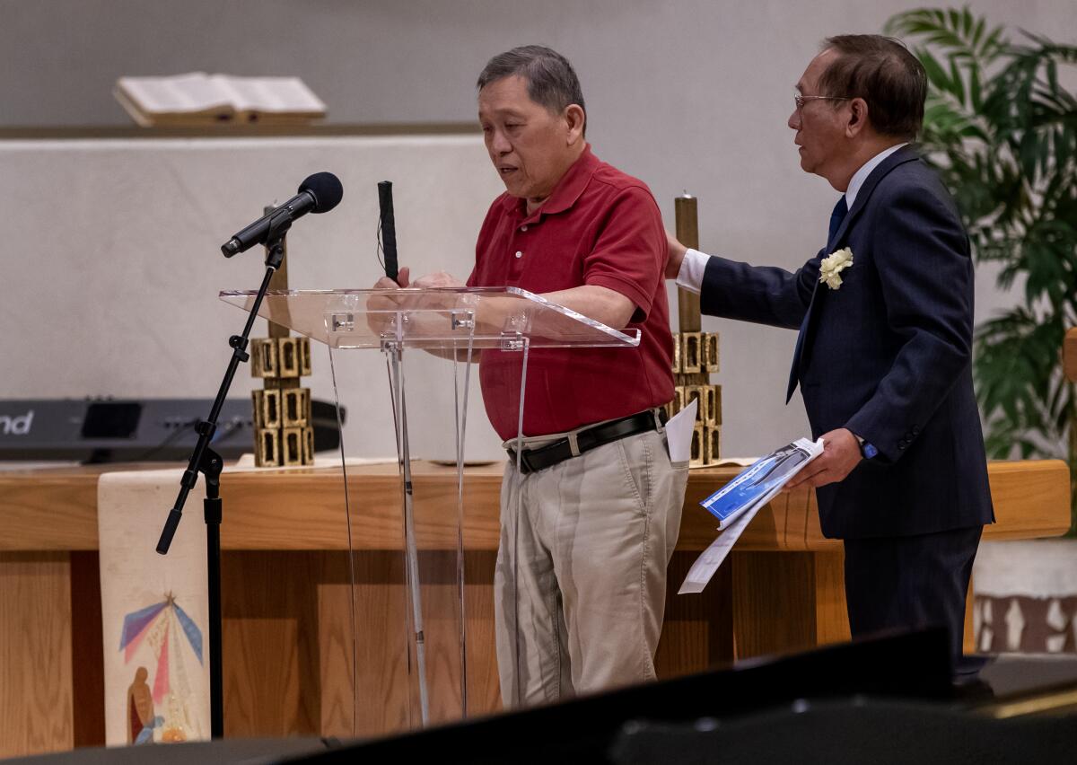 Parishioner Jerry Chen helps visually impaired shooting survivor Li-Yen Hong to the lectern.