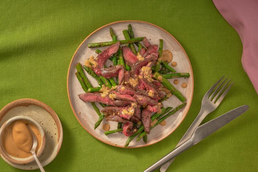 Meat and asparagus on a plate.