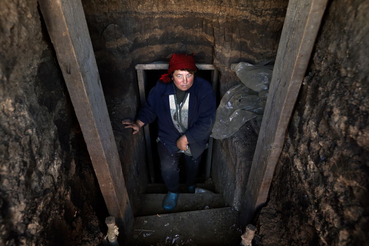 A woman in a red hat and dark clothes is standing in a narrow stairwell
