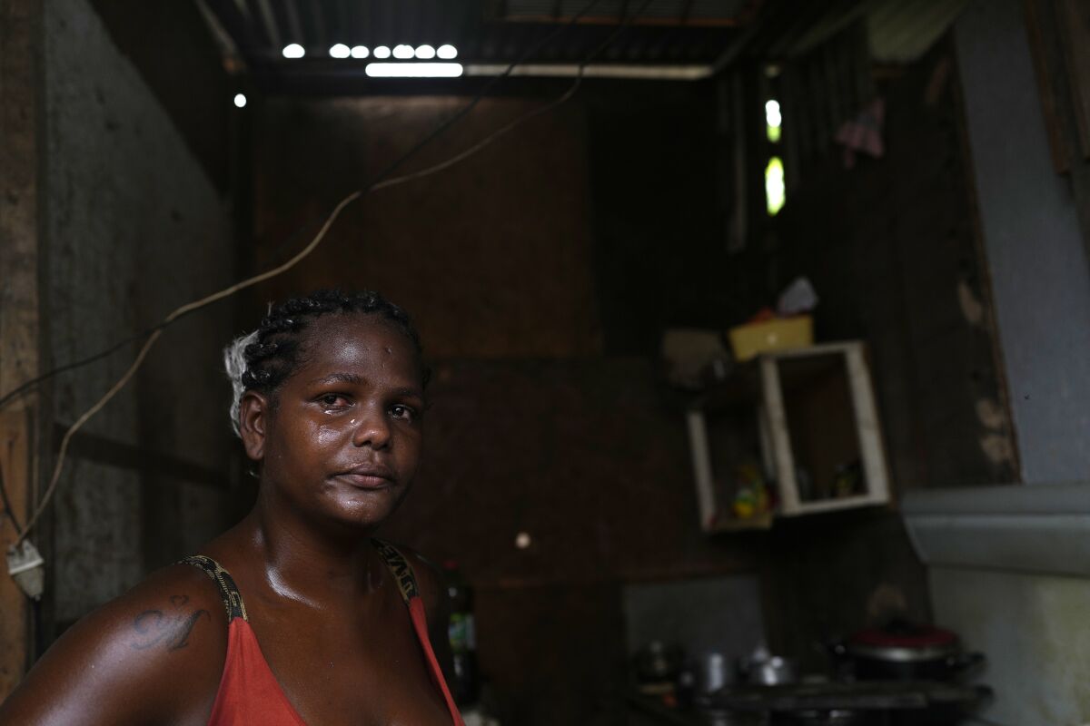 Francielle de Santana cries as she explains that some days her family doesn't have food to eat, at their home in the Jardim Gramacho favela of Rio de Janeiro, Brazil, Monday, Oct. 4, 2021. Surging inflation on food and electricity are affecting the poor, with rising gas prices forcing some to cook with firewood and alcohol. (AP Photo/Silvia Izquierdo)