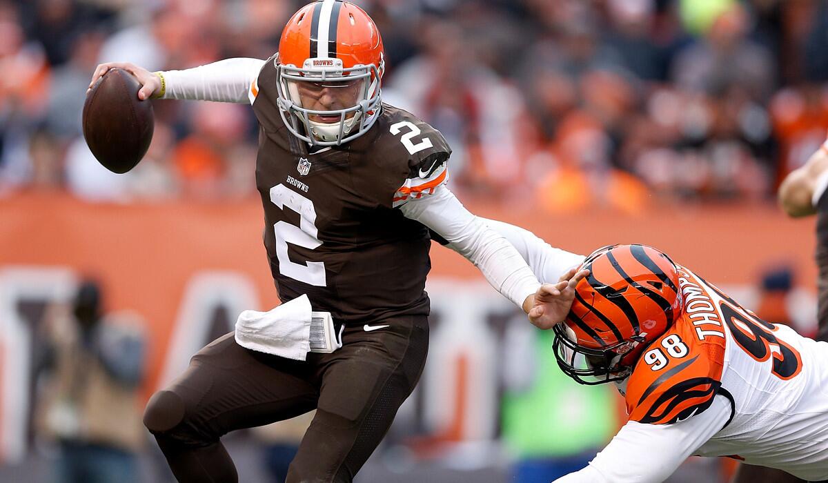 Browns quarterback Johnny Manziel (2) fends off a tackle attempt by Bengals defensive lineman Brandon Thompson in the third quarter Sunday.