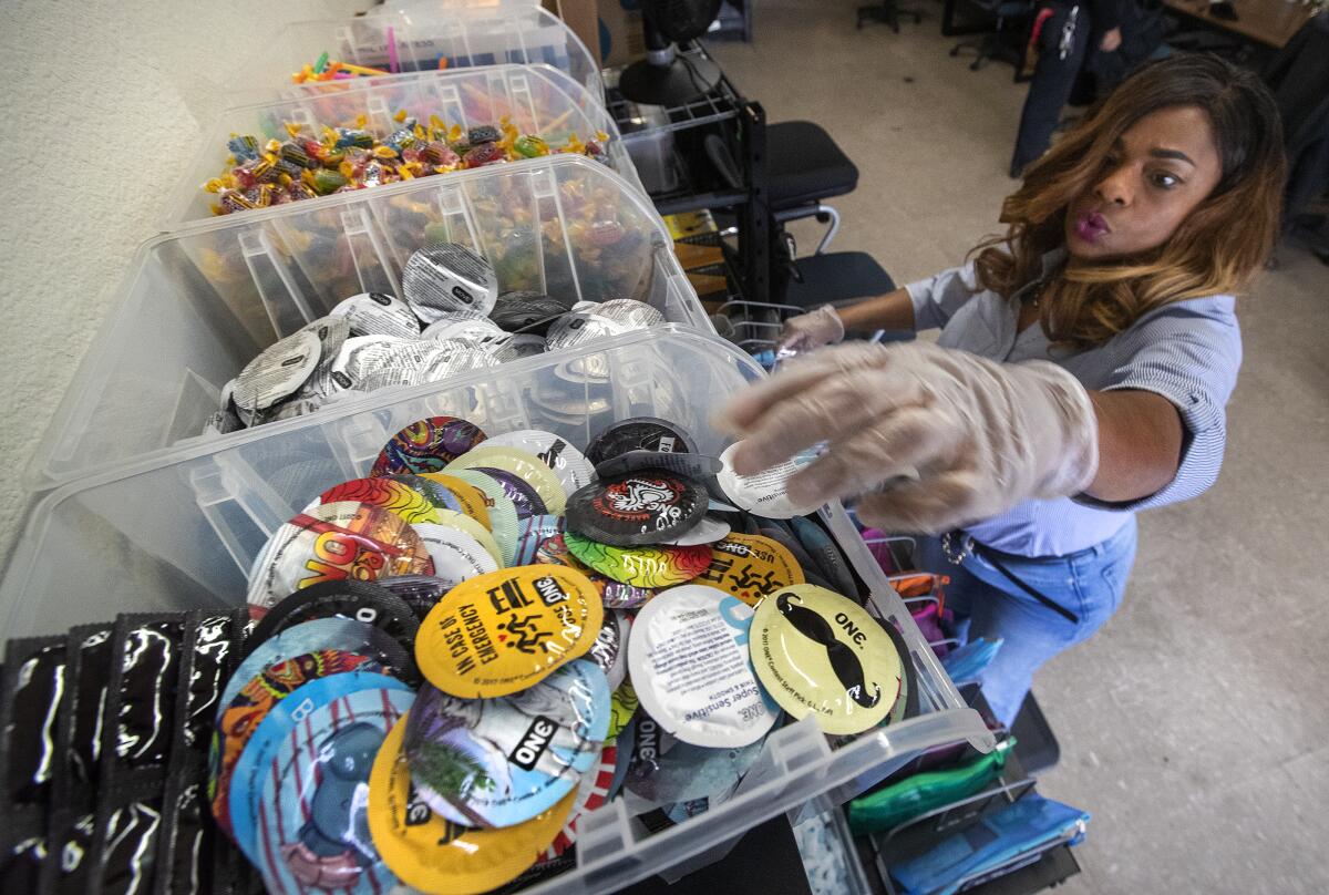 A person assembles kits that includes condoms to be distributed to homeless people in L.A. County.