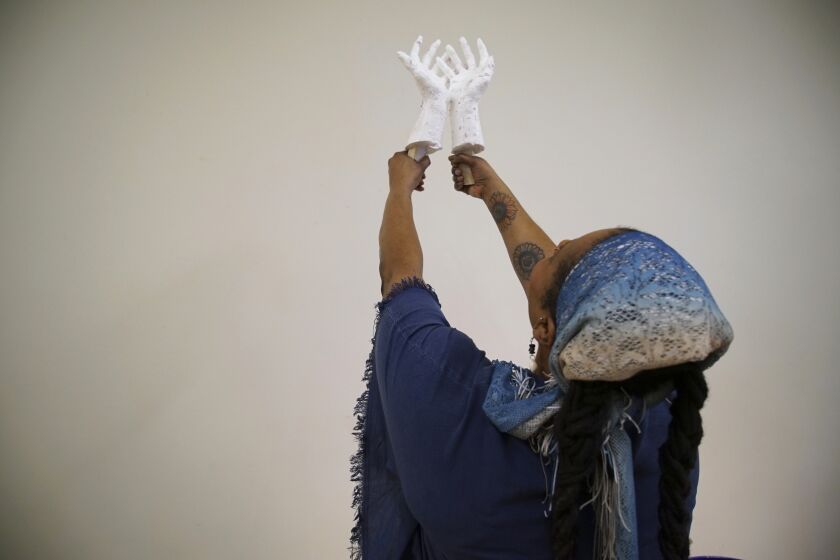 Crystal Kornickey holds up casts of her hands in a studio at the Gibbes Museum of Art in Charleston, S.C., on Thursday, Feb. 16, 2023. She is one of 36 people whose hands will be cast in bronze for a memorial to the likely enslaved people discovered in an unmarked burial ground. In recent decades, advances in DNA research have allowed scientists to use ancient remains and peer into the lives of long-dead people. In Charleston, that's meant tracing some of the African roots that were cut off by slavery. (AP Photo/Allen G. Breed)