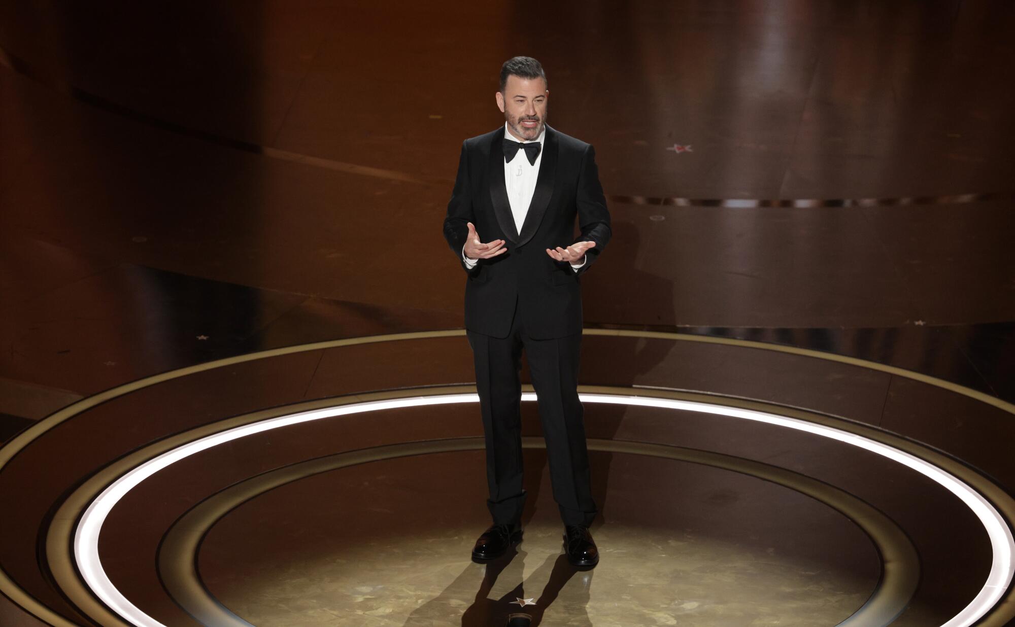 Jimmy Kimmel onstage in a black tuxedo.