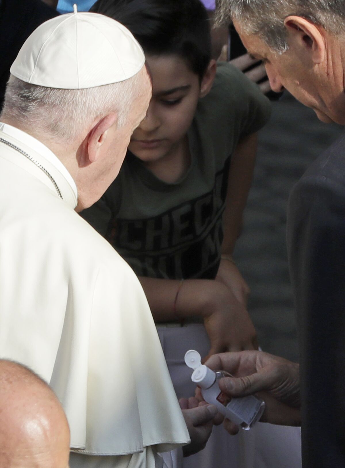 Pope Francis has his hands sanitized by his personal assistant during his weekly general audience general audience in San Damaso courtyard at the Vatican, Wednesday, Sept. 9, 2020. (AP Photo/Andrew Medichini)