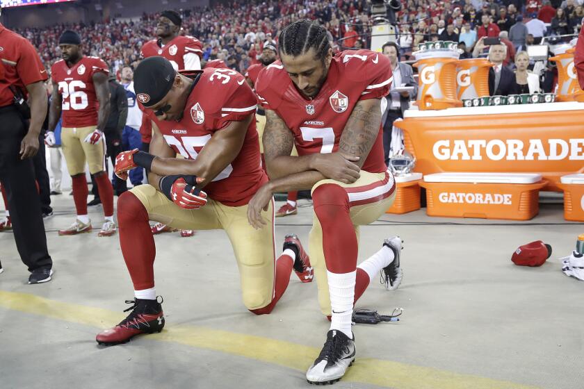 49ers safety Eric Reid, left, and quarterback Colin Kaepernick kneel during the national anthem before a game against the Rams in Santa Clara.