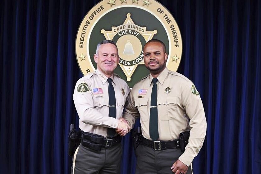 In this undated photo provided by the Riverside County Sheriff, Deputy Darnell Calhoun, right, poses with Riverside County Sheriff Chad Biano, left, in Riverside, Calif. Riverside County Sheriff's Deputy Darnell Calhoun was shot and killed Friday, Jan. 13, 2023 just two weeks after another deputy in the department was slain in the line of duty.(Riverside County Sheriff via AP)