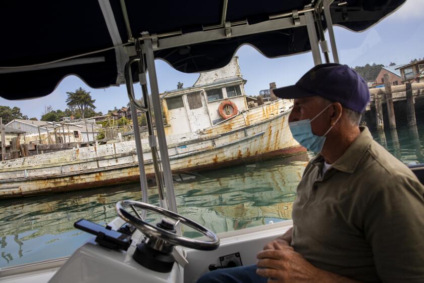 Fort Bragg, CA - August 10: Captain Dan Platt, owner of Noyo Harbor Tours, takes people on a tour down the Noyo River, to where it meets the Pacific Ocean, below the Noyo River Bridge, in Fort Bragg, CA, Tuesday, Aug. 10, 2021. The Valdivia family, who visit the region from Sacramento every summer, took a tour with Captain Dan after debating between horseback riding in the heat and enjoying a cruise on the Noyo River. (Jay L. Clendenin / Los Angeles Times)