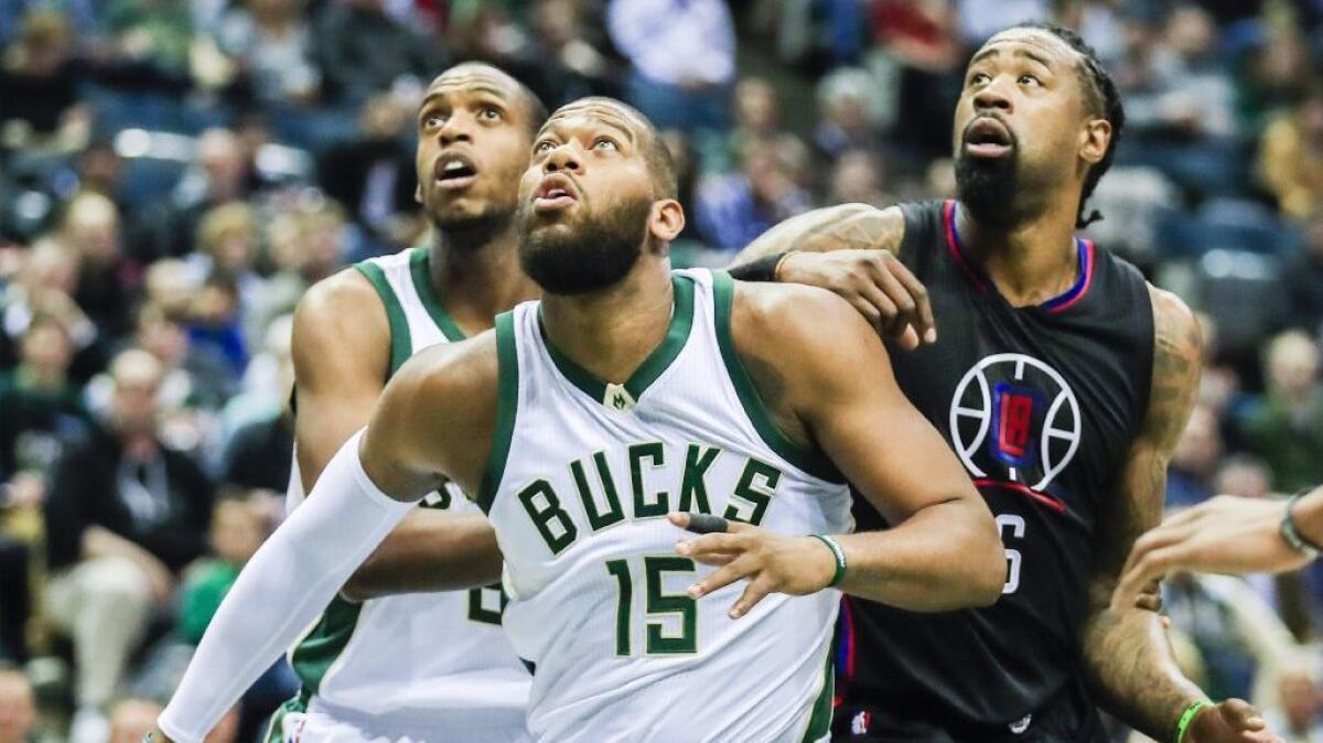 Clippers center DeAndre Jordan is boxed out by Bucks center Greg Monroe (15) and guard Khris Middleton during the first half of a game on March 3, 2017.