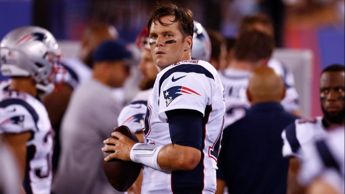 Patriots quarterback Tom Brady warms up on the sideline during a game against the Giants on Sept. 1.