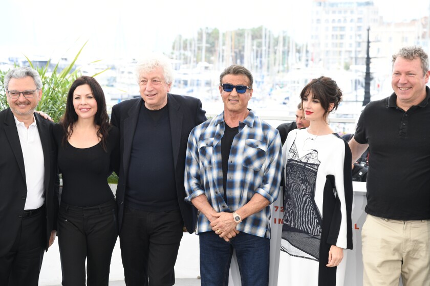 Sylvester Stallone pose avec un groupe de personnes 