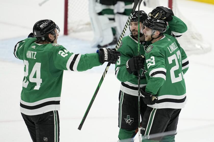 Dallas Stars' Roope Hintz (24), Chris Tanev (3) and Esa Lindell (23) celebrate Lindell's empty-net goal against the Colorado Avalanche late in the third period in Game 2 of an NHL hockey Stanley Cup second-round playoff series in Dallas, Thursday, May 9, 2024. (AP Photo/Tony Gutierrez)