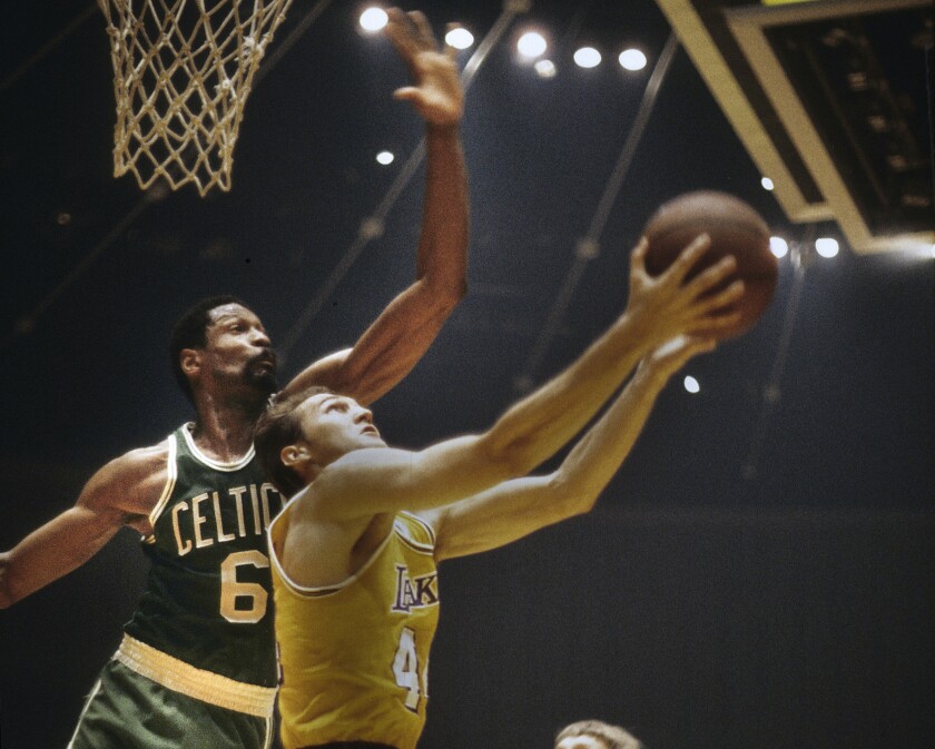 Lakers star Jerry West attempts a reverse layup against Boston Celtics great Bill Russell during a game in the 1960s.