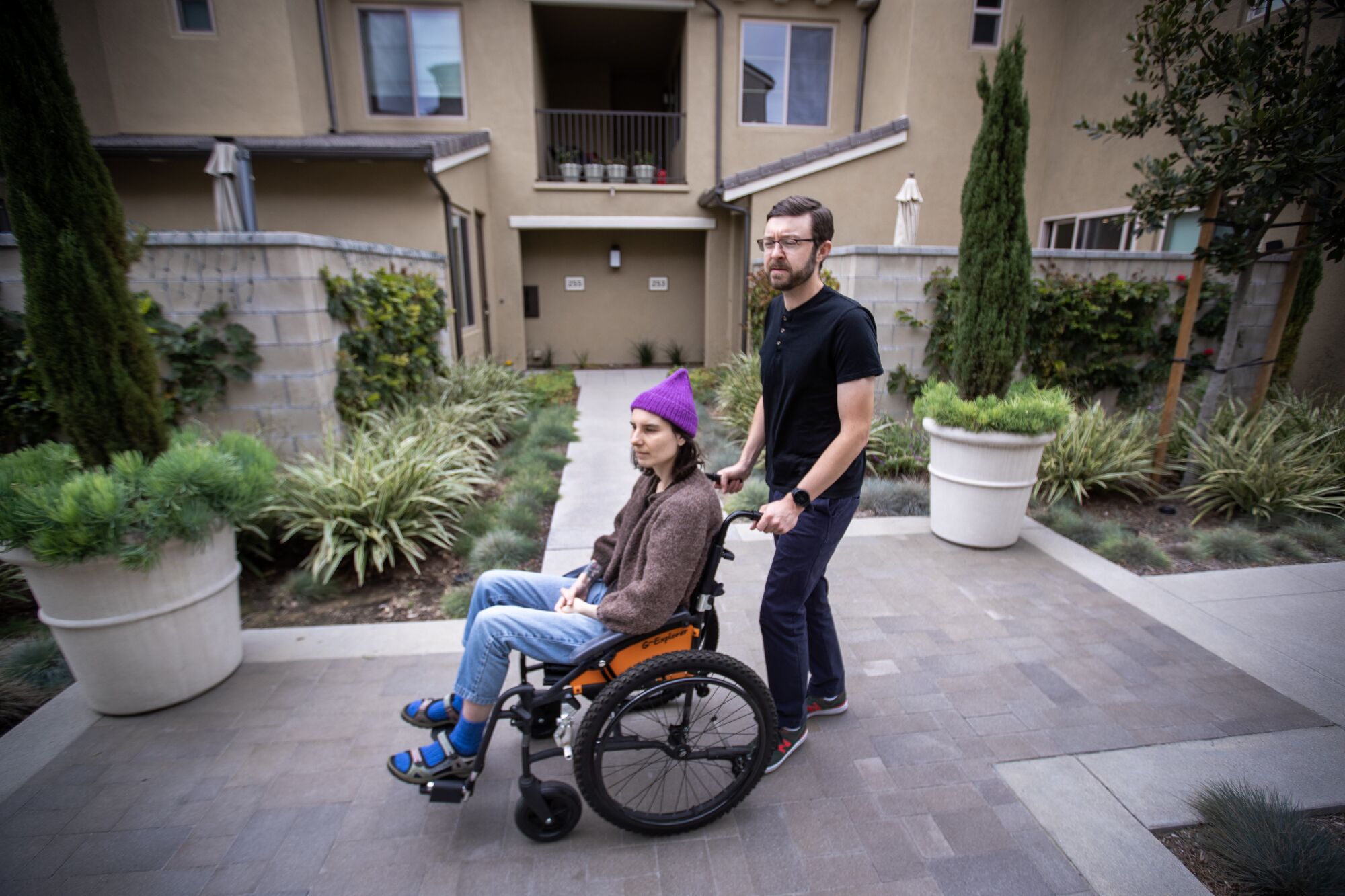 Connor Mayer pushes his partner Courtney Garvin in a wheelchair as they go outside for some fresh air.