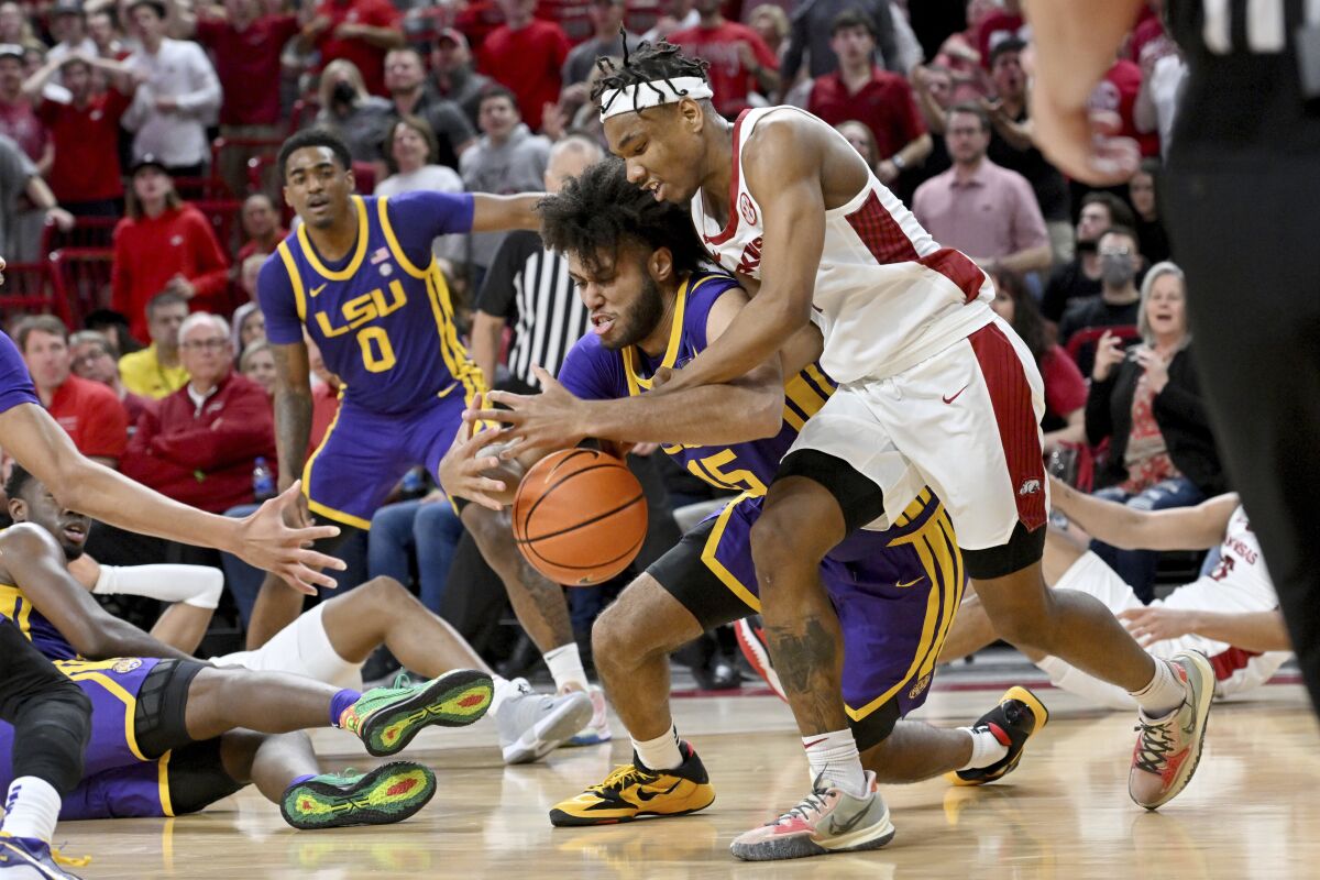 Arkansas guard JD Notae (1) and LSU center Efton ReidIII (15) fight for control of the ball during the first half of an NCAA college basketball game Wednesday, March 2, 2022, in Fayetteville, Ark. (AP Photo/Michael Woods)