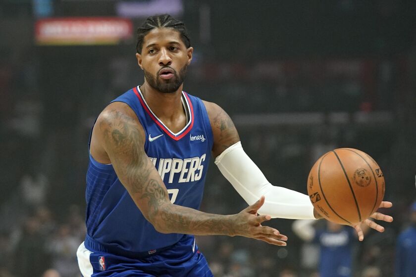 Los Angeles Clippers guard Paul George passes the ball during the first half of an NBA basketball game.