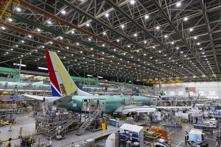 FILE - Boeing employees work on the 737 MAX on the final assembly line at Boeing's Renton plant, June 15, 2022 in Renton, Wash. The SEC announced Thursday, Sept. 22, 2022, that Boeing Co. will pay $200 million to settle allegations that the company and its former CEO misled investors about the safety of its 737 Max after two of the airliners crashed, killing 346 people. (Ellen M. Banner/The Seattle Times via AP, Pool, File)