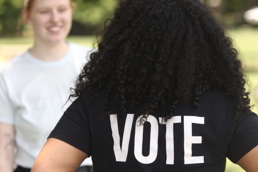 Anita Alexander, vicepresidenta del grupo de Kansas Loud Light, lleva una camiseta que invita a votar, en el campus de la Universidad de Washburn, el viernes 18 de mayo de 2024, en Topeka, Kansas. (AP Foto/John Hanna)