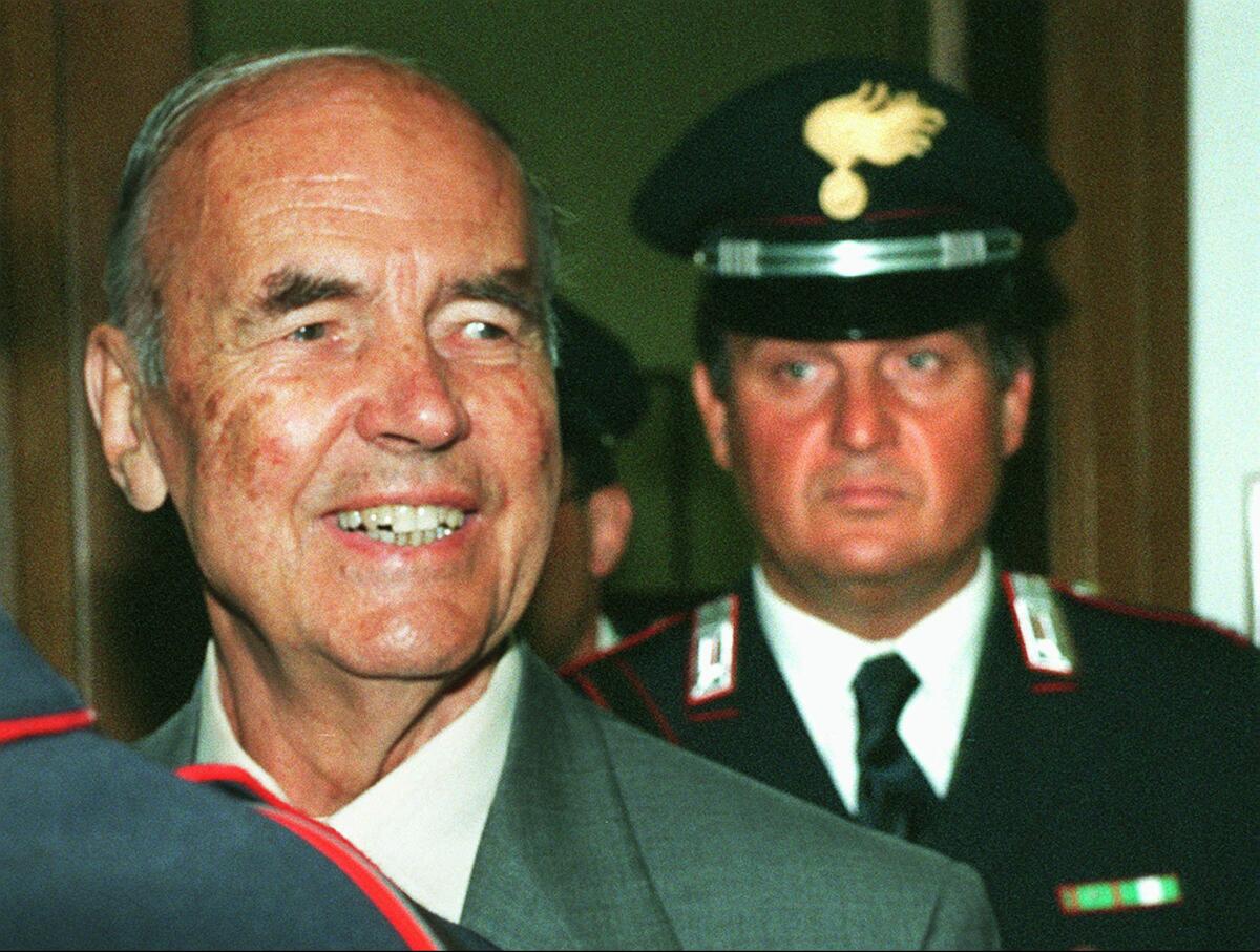 Former Nazi officer Erich Priebke, left, arrives in a military court in Rome on July 10, 1996, for a hearing in his trial. Priebke, a former Nazi SS captain who received a life sentence for his role in one of the worst atrocities by German occupiers in Italy during World War II, died last week at age 100.
