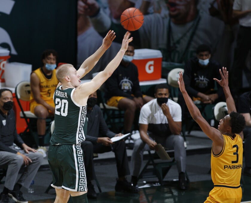 Michigan State's Joey Hauser, left, shoots against Oakland's Micah Parrish (3) during the first half of an NCAA college basketball game, Sunday, Dec. 13, 2020, in East Lansing, Mich. (AP Photo/Al Goldis)