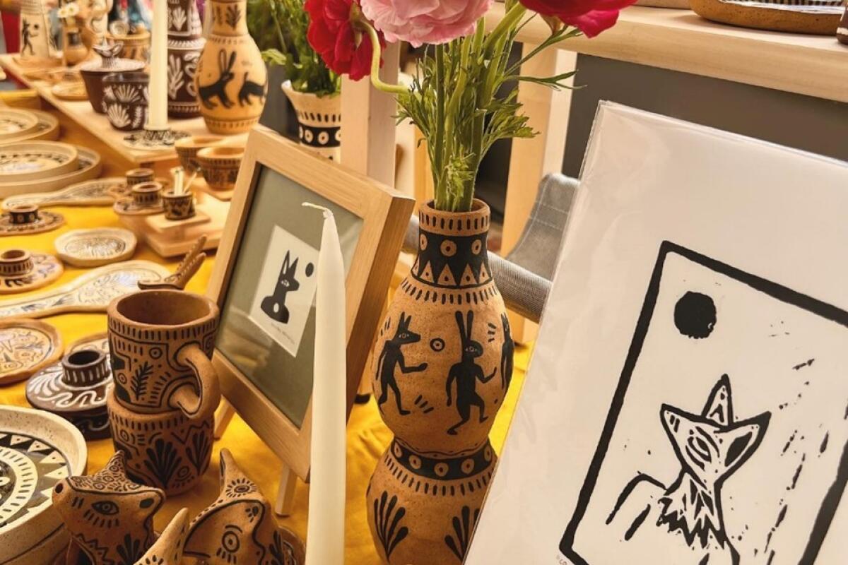 Pottery with flowers and a candle and prints at the Craft Contemporary Holiday Marketplace
