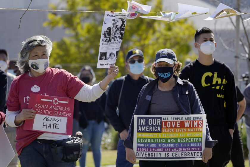 People attend a community rally to raise awareness of anti-Asian violence and racist attitudes, in response to the string of violent racist attacks against Asians during the pandemic, held at Los Angeles Historic Park near the Chinatown district in Los Angeles, Saturday, Feb. 20, 2021. (AP Photo/Damian Dovarganes)