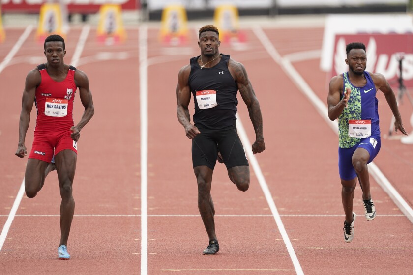 Seattle Seahawks wide receiver DK Metcalf, center, competes in the second heat of the men's 100-meter dash prelim during the USATF Golden Games at Mt. San Antonio College Sunday, May 9, 2021, in Walnut, Calif. At left is Felipe Bardi Dos Santos and at right is Abdullah Mohammed. (AP Photo/Ashley Landis)