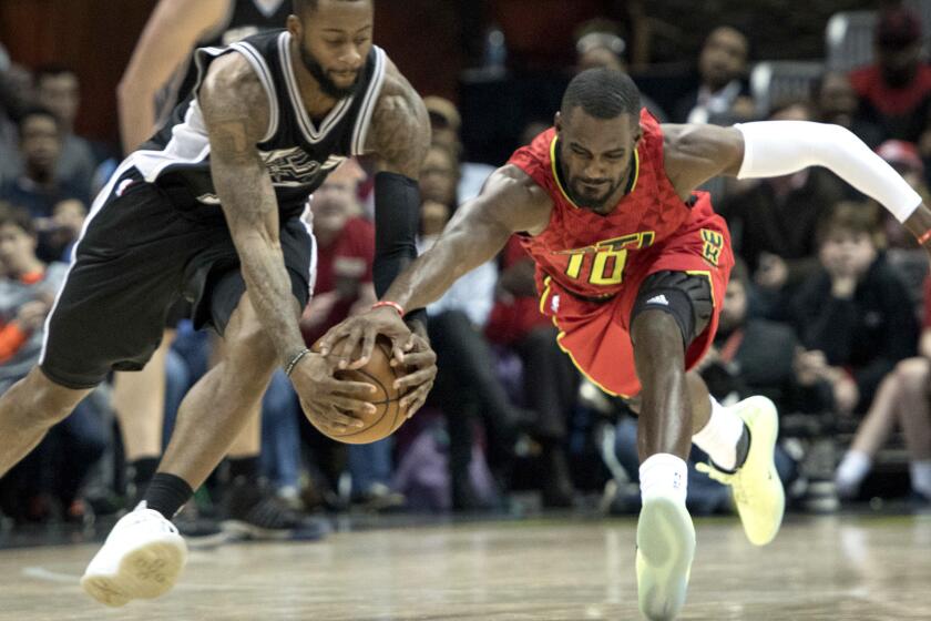 Spurs guard Jonathon Simmons, left, and Hawks guard Tim Hardaway Jr. (10) vie for a loose ball during the second half Sunday.
