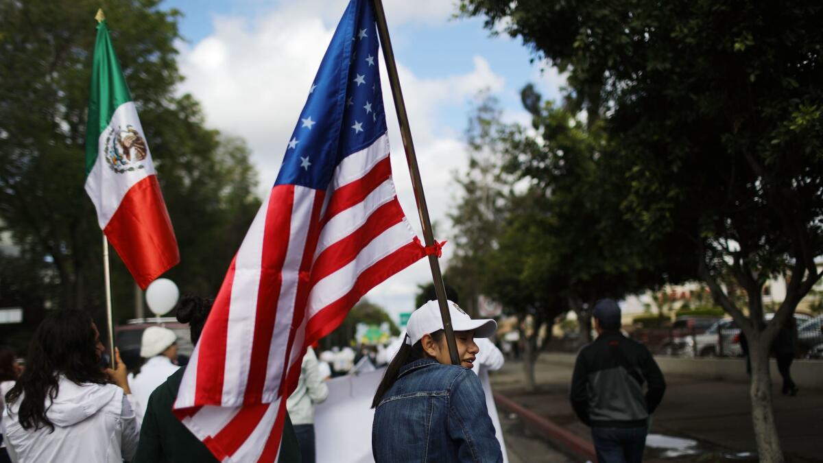 U.S. and Mexican flags are carried at a peace march near the border in Tijuana