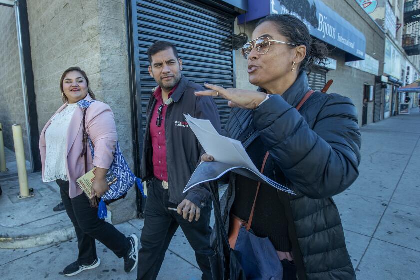 LOS ANGELES, CA-DECEMBER 9, 2022: UCLA professor Kelly Lytle Hernandez, right, walks along Main St. in downtown Los Angeles, while giving a tour to newly elected Los Angeles city council members Eunisses Hernandez and Hugo Soto-Martinez, tracing the steps of Ricardo Flores Magon, the Mexican anarchist who organized from Los Angeles in the early 1900's and helped to spark the Mexican Revolution. (Mel Melcon / Los Angeles Times)