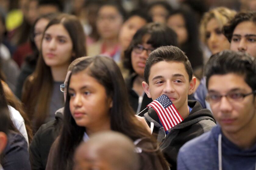 SAN DIEGO, CA 11/17/2017: 13- year-old old Hadi Alwakeel of El Cajon, born in Iraq, was one of the 100 children from 25 different countries to become naturalized American citizens during a special children's citizenship ceremony held at the New Americans Museum in Liberty Station, is all smiles and waves an American flag during the ceremony. Staff photo by Howard Lipin/The San Diego Union-Tribune/ZUMA Press Copyright 2017 The San Diego Union-Tribune