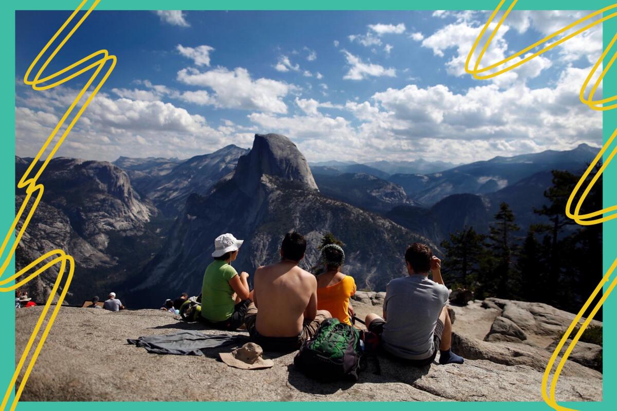 Visitors sit on rocks at Glacier Point looking out over Yosemite National Park.