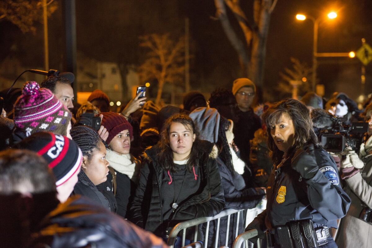 Minneapolis Police Chief Janee Harteau, right, speaks with protestors separated by a barricade outside the 4th Precinct police station Friday night.