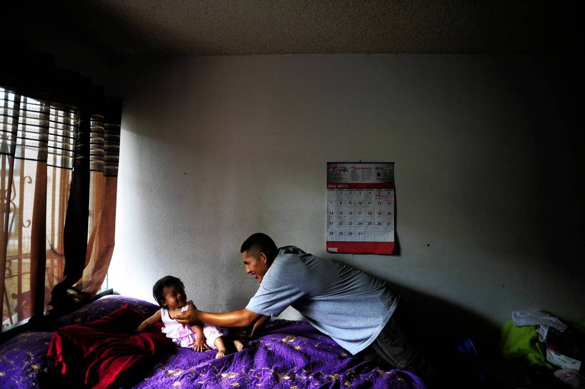 Frank Mariano, 16, a participant in the L.A. Fathers Program at Children's Hospital Los Angeles, plays with his 1-year-old daughter, Anabell, in their Koreatown home.