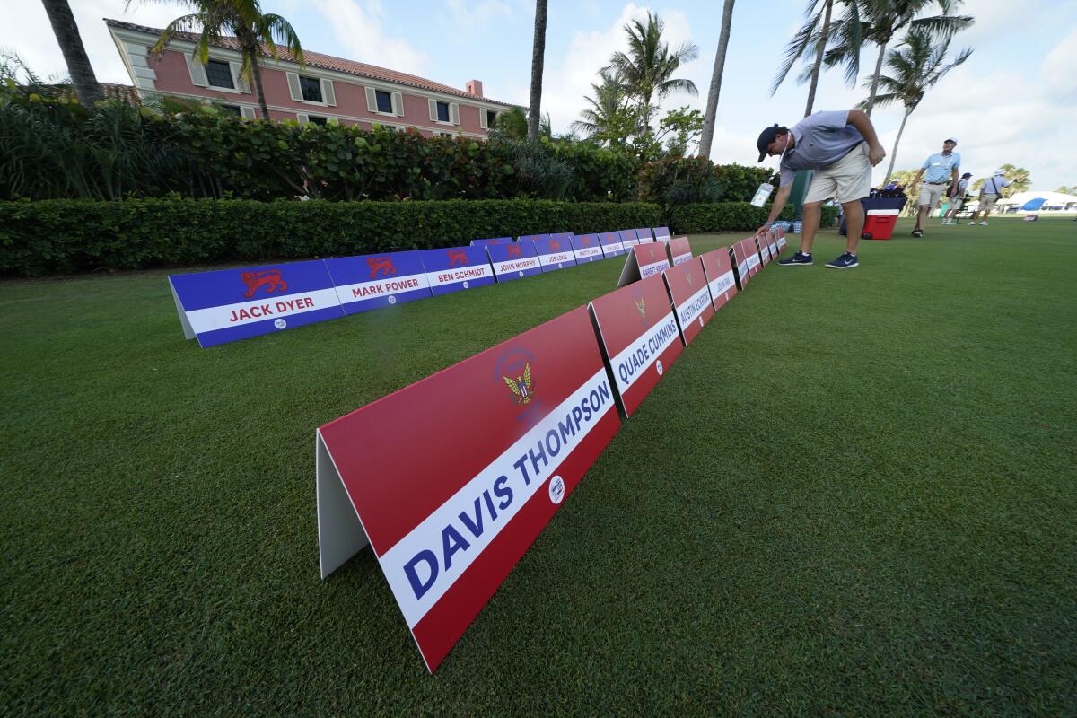 A man places signs with team members names for the USA team and the Great Britain and Ireland team, on a practice day for the Walker Cup golf tournament, which starts tomorrow, at Seminole Golf Club in Juno Beach, Fla., Friday, May 7, 2021. (AP Photo/Gerald Herbert)