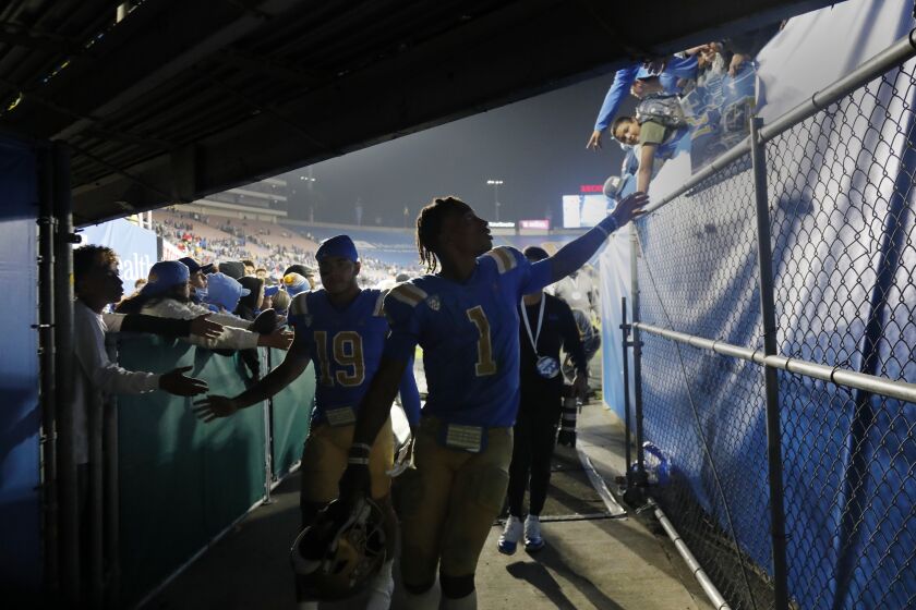 PASADENA, CA - SEPTEMBER 18, 2021: UCLA Bruins quarterback Dorian Thompson-Robinson (1) reaches out to fans as he heads to the locker room after a disappointing loss to Fresno State 40-37 at the Rose Bowl on September 18, 2021 in Pasadena, California.(Gina Ferazzi / Los Angeles Times)