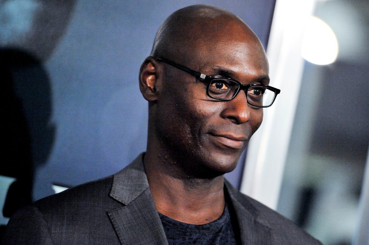 A smiling bald Black man with glasses