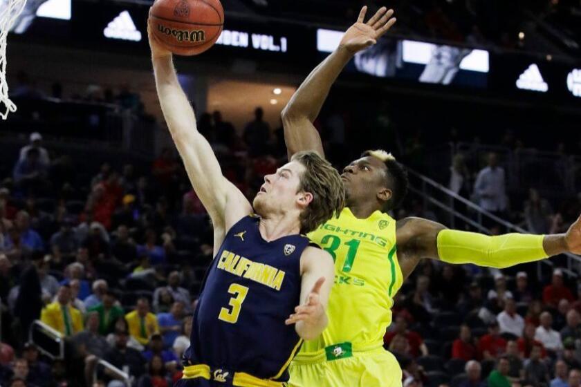 Oregon's Dylan Ennis fouls California's Grant Mullins during the second half of a Pac-12 tournament semifinal game on March 10.
