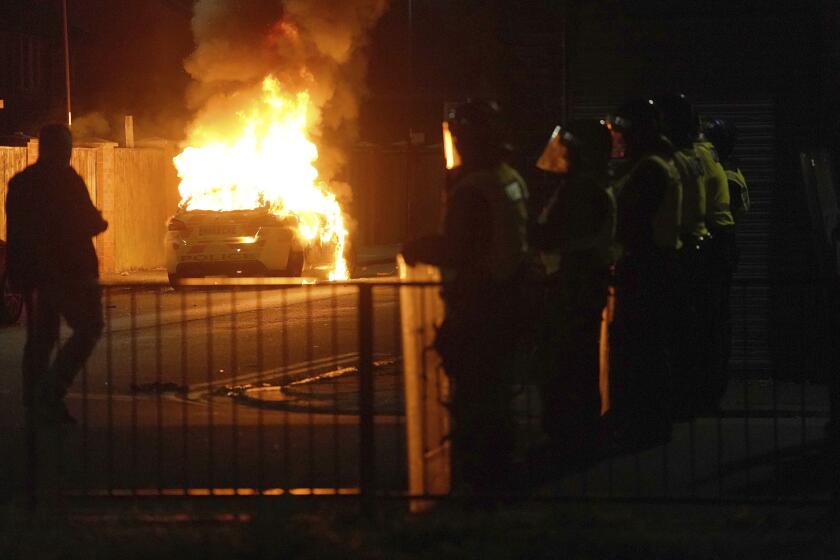 A police car burns as officers are deployed on the streets of Hartlepool, England, following a violent protest in the wake of the killing of three girls who were fatally stabbed in northwest England, Wednesday, July 31, 2024. Far-right groups seek to stir anger over an attack they have sought to link — without evidence — to immigrants. (Owen Humphreys/PA via AP)