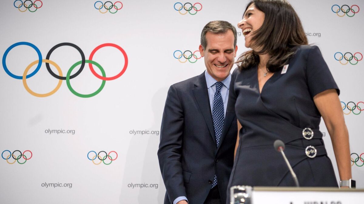 L.A. Mayor Eric Garcetti laughs with Anne Hidalgo, mayor of Paris, during a news conference following an International Olympic Committee session July 11 in Lausanne, Switzerland.