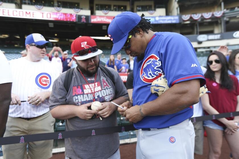 Cubs hitting consultant Manny Ramirez signs balls for a fan before the season opener against the Angels at Angel Stadium of Anaheim on April 5, 2016.
