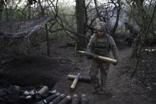 A Ukrainian serviceman from Azov brigade known by call sign Ray, 20, carries a shell for the OTO Melara Mod 56 howitzer on the frontline in Kreminna direction, Donetsk region, Ukraine, Thursday, April 11, 2024. (AP Photo/Alex Babenko)